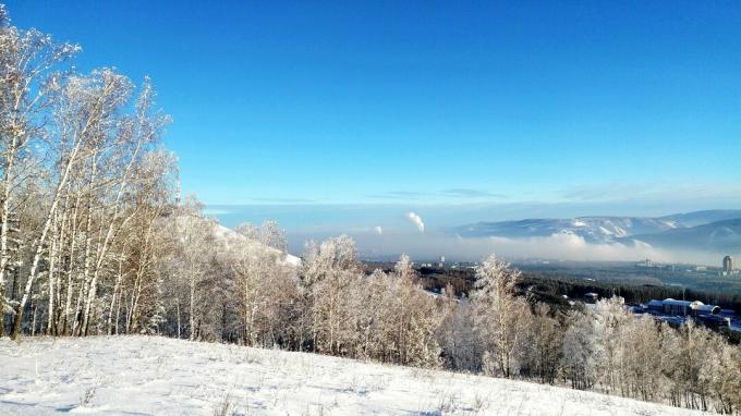 Сликовит поглед на снег прекривен пејзаж насупрот плавом небу