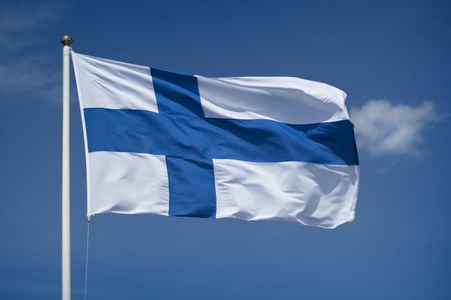 Истакнута финска застава са позадином плавог неба