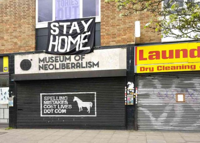 Велики знак СТАИ ХОМЕ изнад затвореног Музеја неолиберализма у Левсихаму у Лондону, Енглеска.